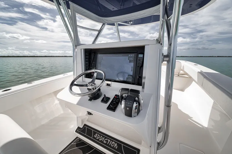 Slide: The Image of Center console of a 2016 Bahama 41 boat with steering wheel and navigation controls. - 7