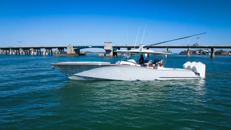 Slide: The Image of 2026 Mag Bay 43 CC boat cruising on a sunny day near a bridge. - 2