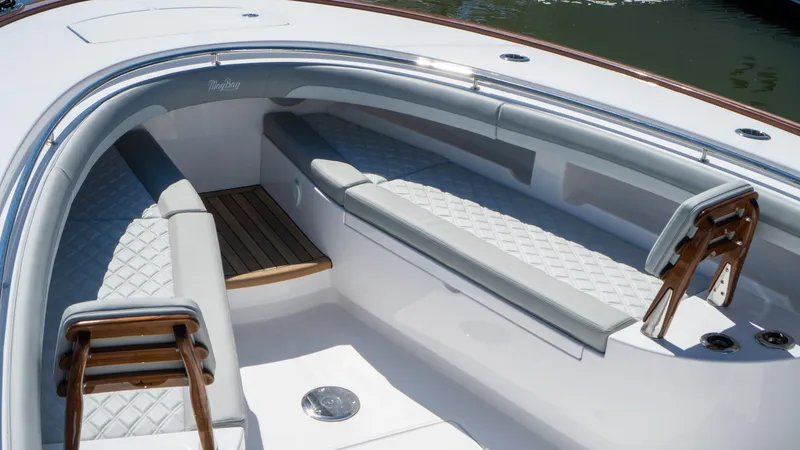 Slide: The Image of 2026 Mag Bay 43 CC boat interior with cushioned seating and wooden accents. - 12