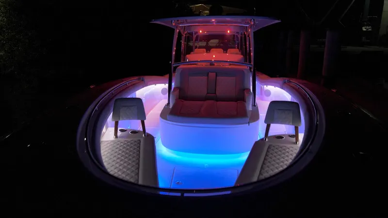 Slide: The Image of 2026 Mag Bay 43 CC boat with vibrant interior lighting at night. - 8