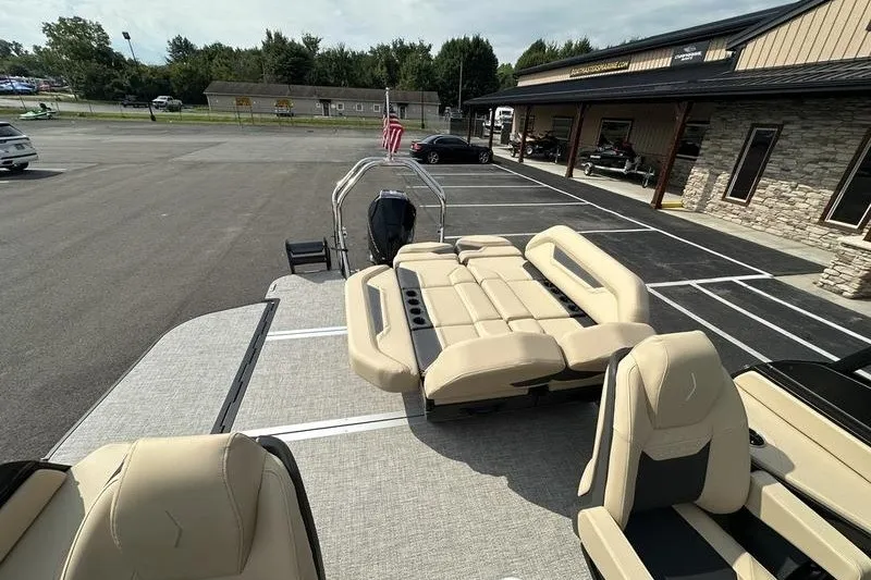 Slide: The Image of 2026 Flamingo Rove 24' boat with beige seating, parked in a lot near a building. - 50