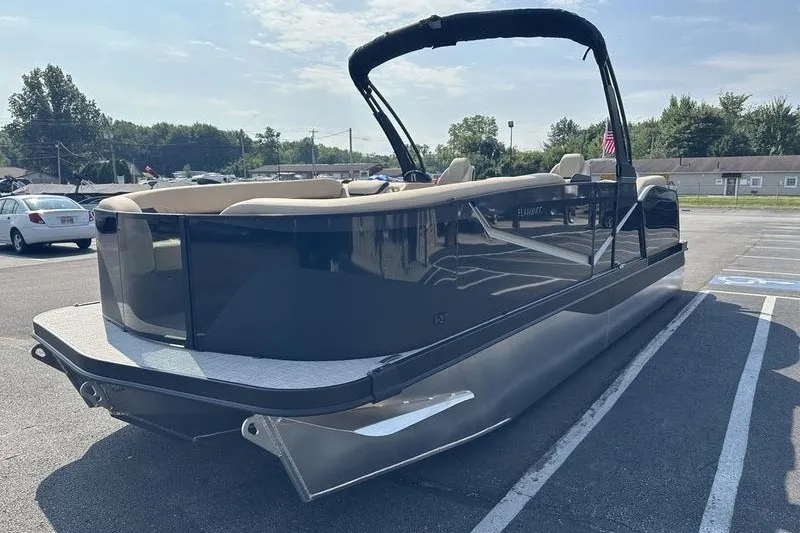Slide: The Image of 2026 Flamingo Rove 24' pontoon boat parked in a lot under a clear sky. - 24