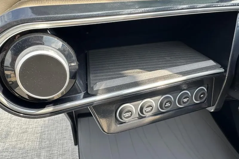 Slide: The Image of 2026 Flamingo Rove 24' dashboard with control knobs and storage compartment. - 29