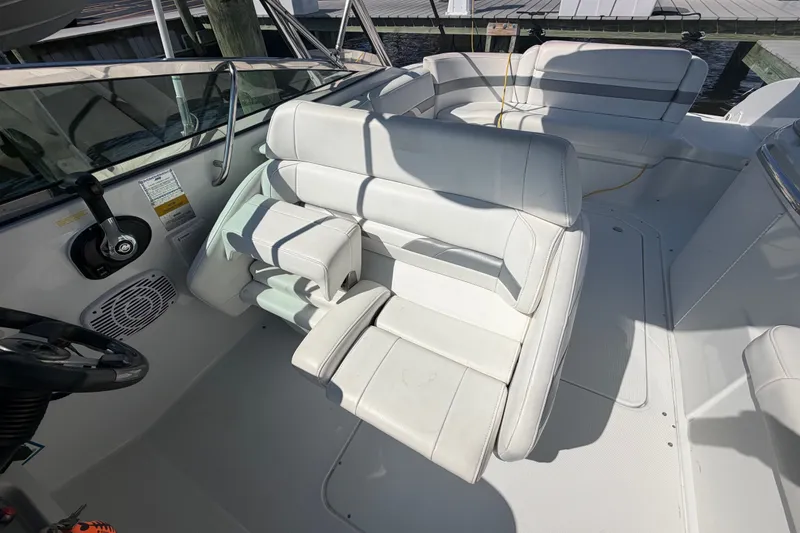 Slide: The Image of 2004 Formula 260 Bowrider boat interior with white seating and steering wheel. - 14