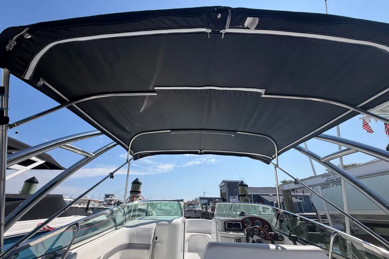 Slide: The Image of 2004 Formula 260 Bowrider boat interior with canopy, docked at marina under clear sky. - 31