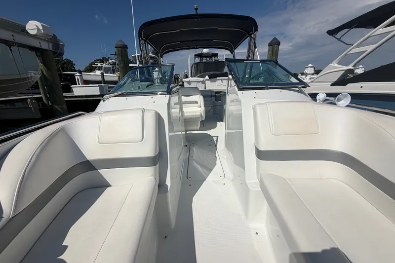 Slide: The Image of 2004 Formula 260 Bowrider boat with white seating, docked at a marina under a clear sky. - 13