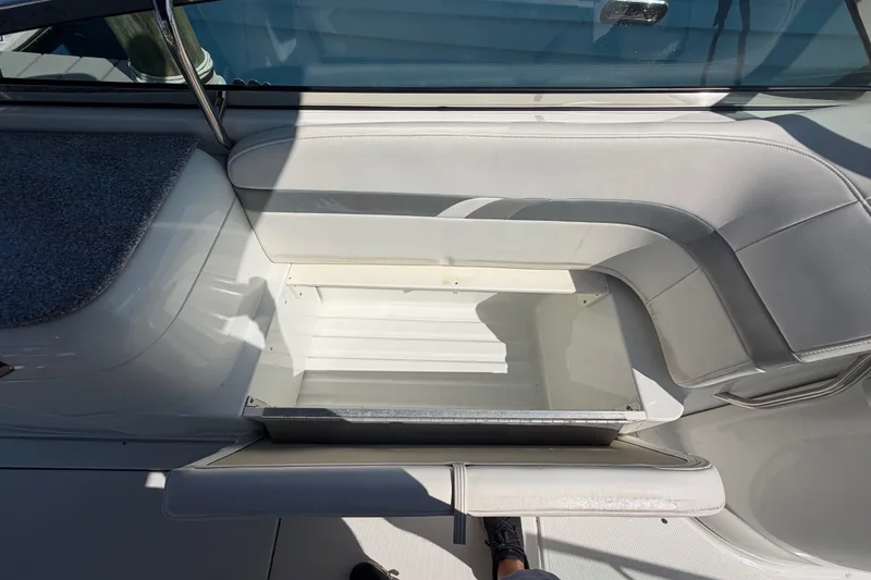 Slide: The Image of Open storage compartment on a 2004 Formula 260 Bowrider boat with white seating. - 23
