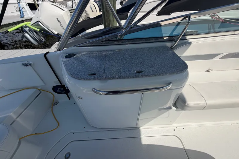 Slide: The Image of 2004 Formula 260 Bowrider interior with seating and storage, docked near outboard motors. - 28
