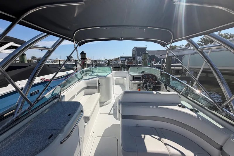 Slide: The Image of 2004 Formula 260 Bowrider boat interior with seating and steering wheel, docked at marina. - 32