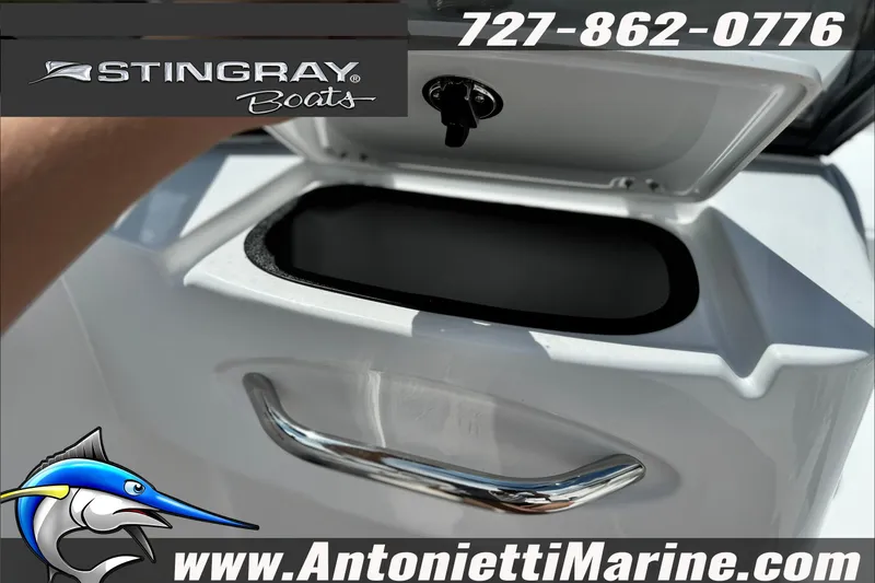 Slide: The Image of Open storage compartment on a 2027 Stingray 19 DC boat, featuring logo and contact details. - 20