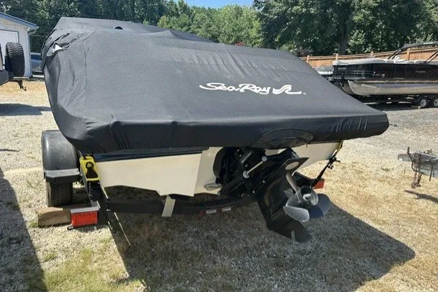 Slide: The Image of 2018 Sea Ray SPX 190 boat with cover, parked on a trailer outdoors. - 17