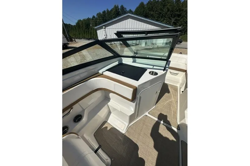Slide: The Image of 2018 Sea Ray SPX 190 boat interior with seating and windshield, parked outdoors. - 22