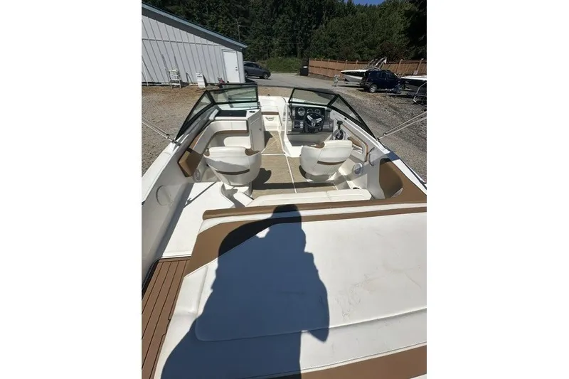 Slide: The Image of 2018 Sea Ray SPX 190 boat interior with seating and steering wheel, parked outdoors. - 27