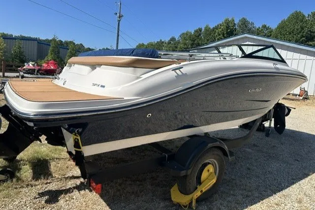 Slide: The Image of 2018 Sea Ray SPX 190 boat on trailer, parked outdoors under clear sky. - 12