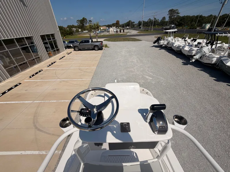 Slide: The Image of The image shows the helm of a 2027 Savannah 220 IS boat parked on a lot. - 13