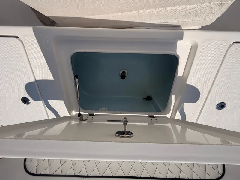 Slide: The Image of An open storage compartment on a 2027 Savannah 220 IS boat, featuring a blue interior. - 17