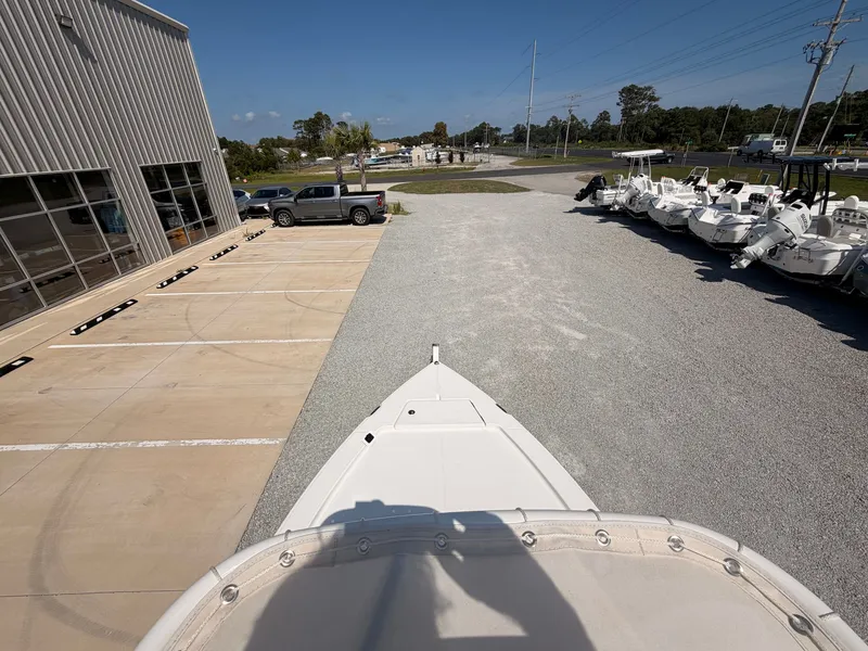 Slide: The Image of A Savannah 220 IS boat is on a gravel lot next to a building and other boats. - 14