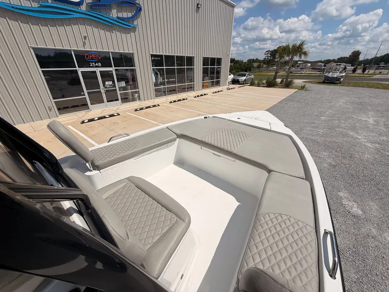 Slide: The Image of The image shows the bow area of a 2027 Savannah 210X boat with gray upholstery. - 10