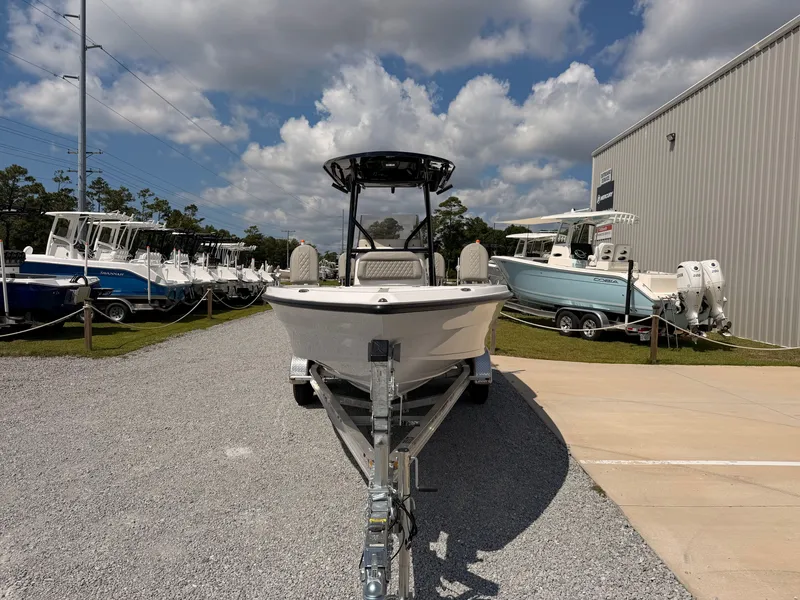 Slide: The Image of A 2027 Savannah 210X boat on a trailer in front of a building, surrounded by other boats. - 6