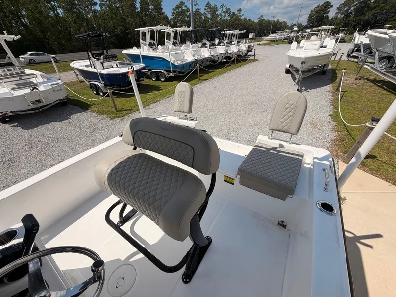 Slide: The Image of The image shows the cockpit of a 2027 Savannah 210X boat with cushioned seating. - 12