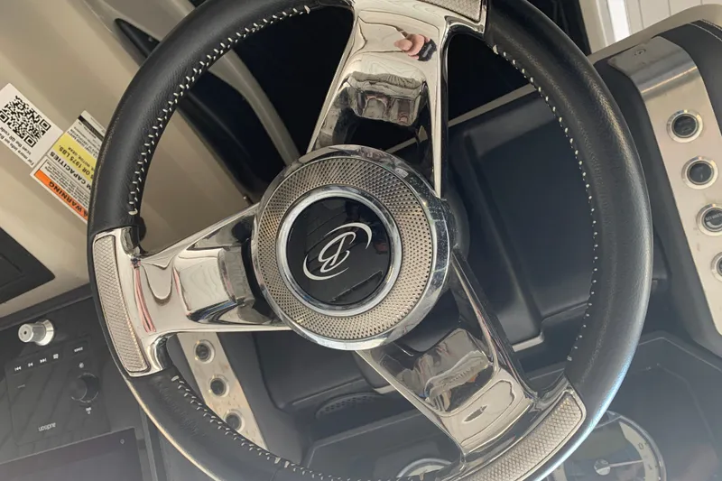 Slide: The Image of Steering wheel of 2022 Barletta LUSSO 25U pontoon boat, featuring sleek chrome accents. - 19
