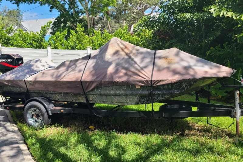 Slide: The Image of Covered 2000 War Eagle 761 Blackhawk boat on trailer, parked on grass. - 13