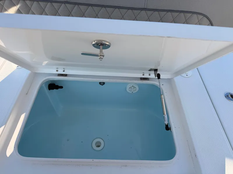 Slide: The Image of An open storage compartment on a 2027 Savannah 220 IS boat, featuring a blue interior. - 14