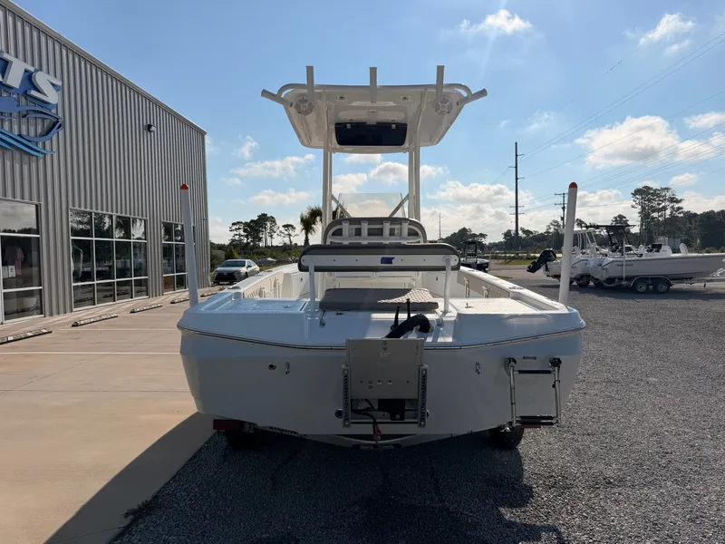 Slide: The Image of A 2027 Savannah 220 IS boat is parked on a lot in front of a building. - 2