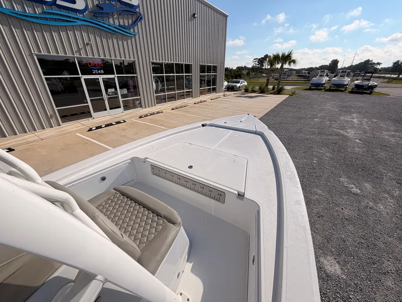 Slide: The Image of The image shows the deck of a 2027 Savannah 220 IS boat in front of a building. - 10