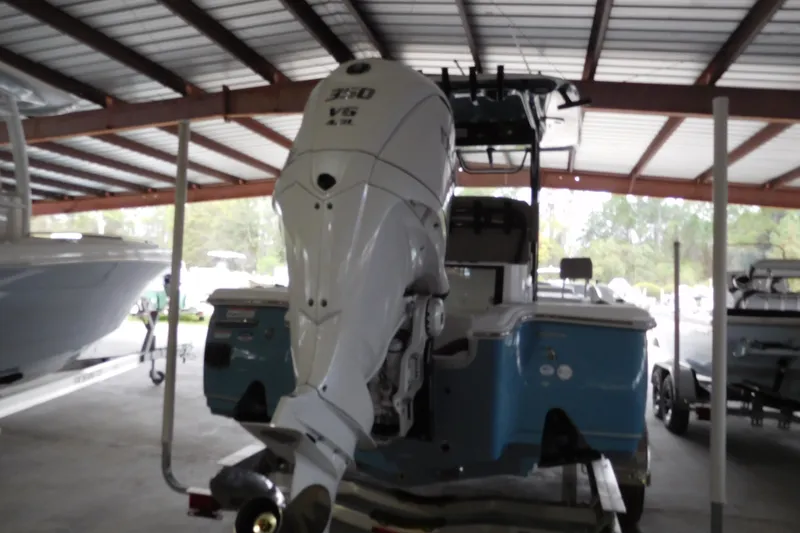 The Image of 2026 Sea Hunt BX25FS boat with powerful outboard motor in covered storage. - 1