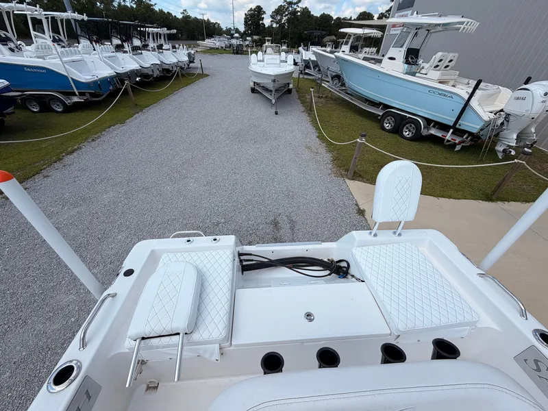 Slide: The Image of The image shows the stern of a 2027 Savannah 210X boat on a gravel lot. - 13