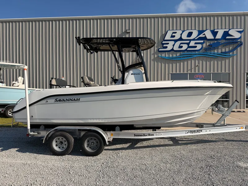 The Image of The image shows a 2027 Savannah 2200 Offshore boat on a trailer in front of a boat building. - 0