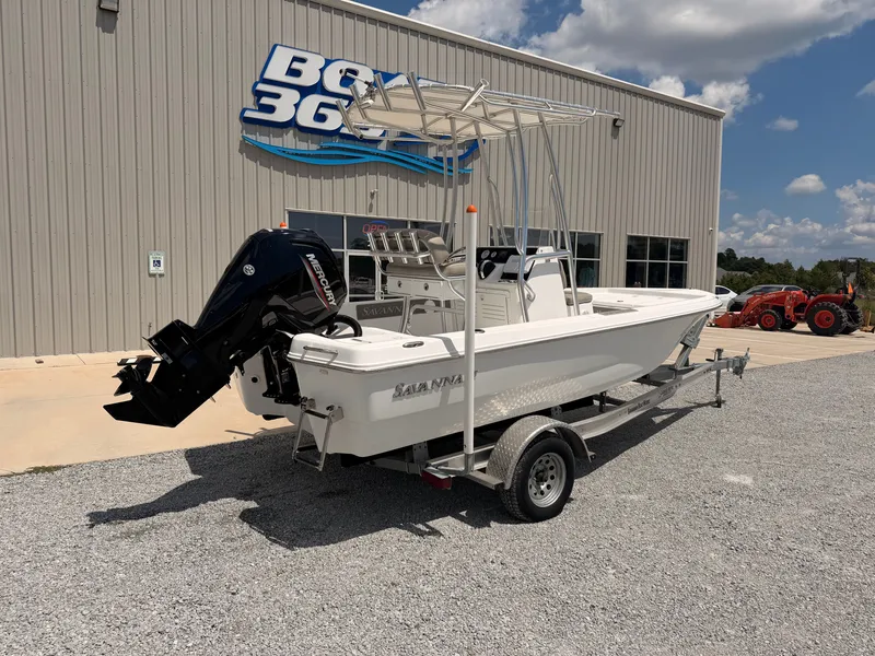 Slide: The Image of A 2027 Savannah 190 IS boat on a trailer in front of a building. - 1