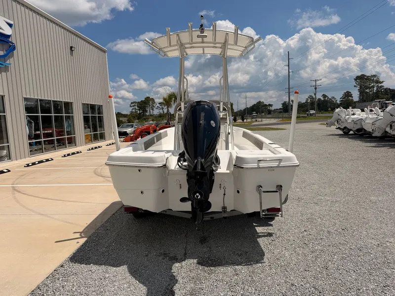 Slide: The Image of A 2027 Savannah 190 IS boat is parked on a gravel lot in front of a building. - 2