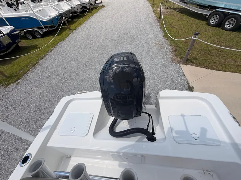 Slide: The Image of A Savannah 190 IS boat with an outboard motor, parked on a gravel path, surrounded by other boats. - 14