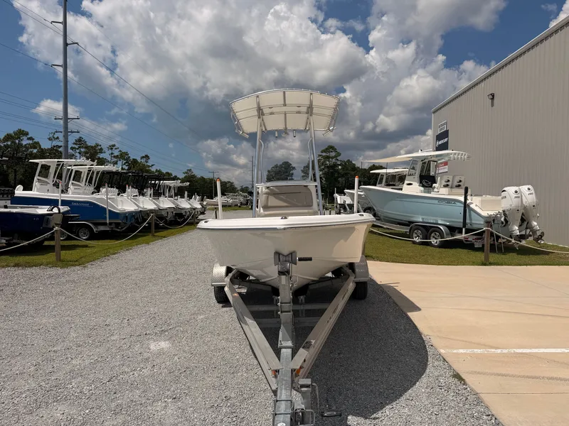 Slide: The Image of A 2027 Savannah 190 IS boat on a trailer in a gravel lot, surrounded by other boats. - 6