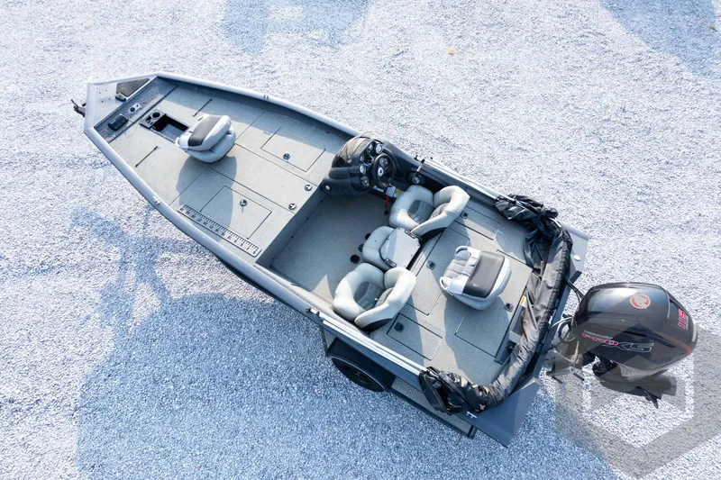 Slide: The Image of 2019 Tracker Pro Team 190 TX fishing boat with seating and motor, on gravel surface. - 30