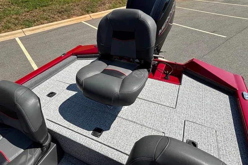 Slide: The Image of 2024 Tracker Pro Team 175 TF boat interior with cushioned seating and motor. - 18