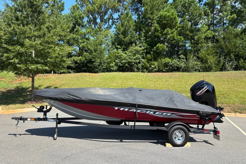 Slide: The Image of 2024 Tracker Pro Team 175 TF boat covered on trailer, parked outdoors. - 15
