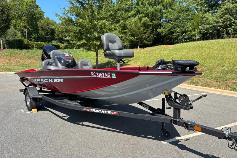 Slide: The Image of 2024 Tracker Pro Team 175 TF boat on trailer, parked outdoors in sunny setting. - 13