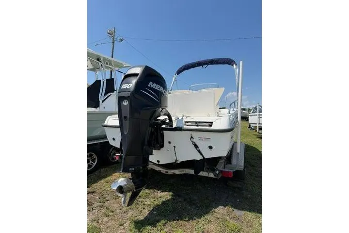 Slide: The Image of 2008 Boston Whaler 180 Dauntless boat with Mercury 150 engine, parked on grass. - 5