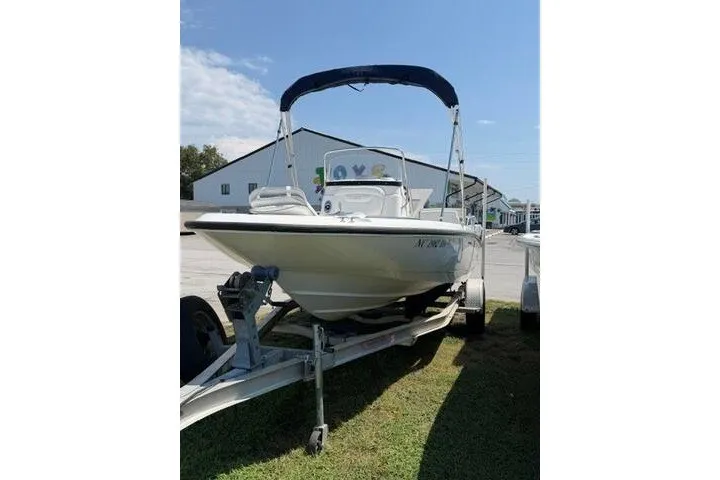 Slide: The Image of 2008 Boston Whaler 180 Dauntless boat on trailer, parked outdoors under blue sky. - 2