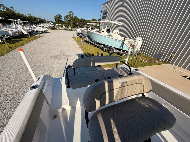 Slide: The Image of The image shows a 2027 Savannah 2200 Offshore boat on a gravel path next to other boats. - 15