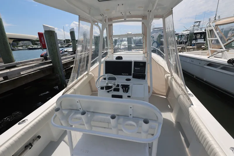 Slide: The Image of 1999 Regulator 26 Forward Seating boat interior at marina, featuring helm and seating area. - 28
