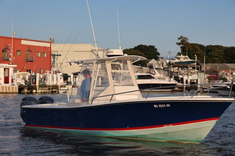 The Image of 1999 Regulator 26 Forward Seating boat docked at marina, sunny day. - 0