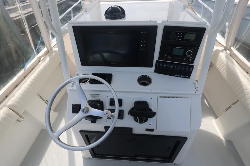 Slide: The Image of 1999 Regulator 26 Forward Seating boat helm with steering wheel and navigation controls. - 16