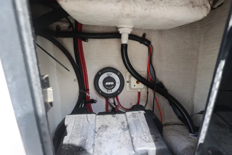 Slide: The Image of Battery compartment of a 1999 Regulator 26 Forward Seating boat with wiring and switch. - 25