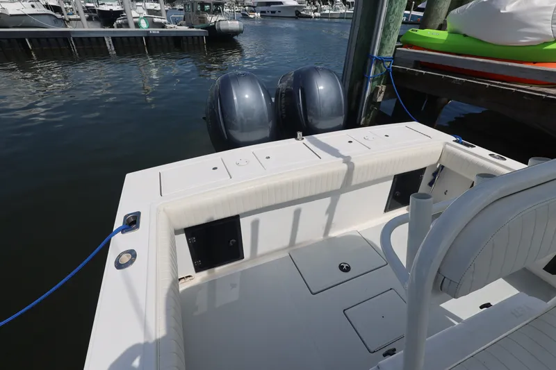 Slide: The Image of 1999 Regulator 26 Forward Seating boat docked with dual outboard motors. - 24