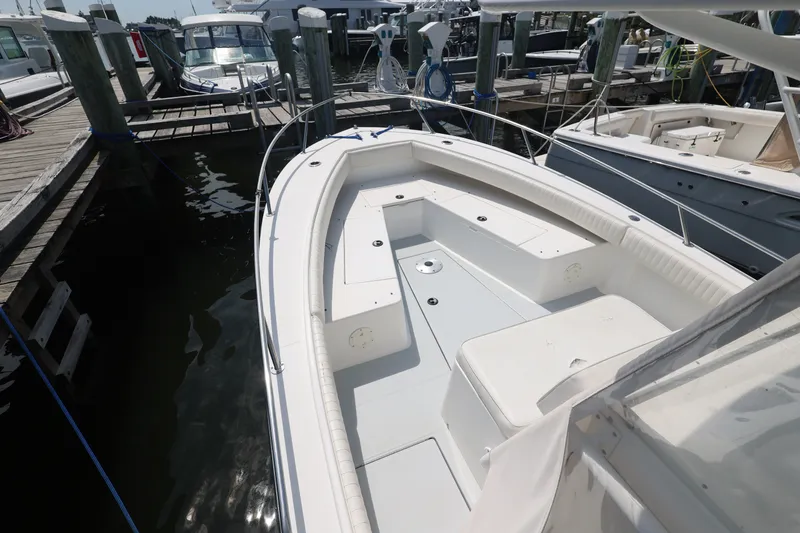 Slide: The Image of 1999 Regulator 26 Forward Seating boat docked at marina, showcasing spacious seating area. - 30