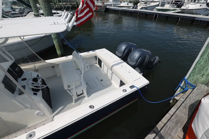 Slide: The Image of 1999 Regulator 26 Forward Seating boat docked with twin Yamaha engines. - 13
